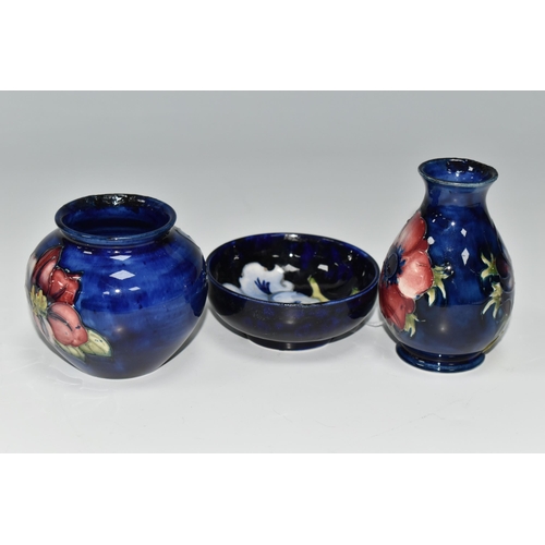 377 - THREE SMALL PIECES OF BLUE GROUND MOORCROFT POTTERY, comprising a shallow footed bowl decorated with... 