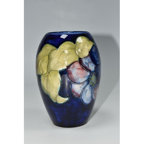 325 - A MOORCROFT POTTERY CLEMATIS PATTERN VASE, the ovoid vase tube lined with purple Clematis flowers on... 