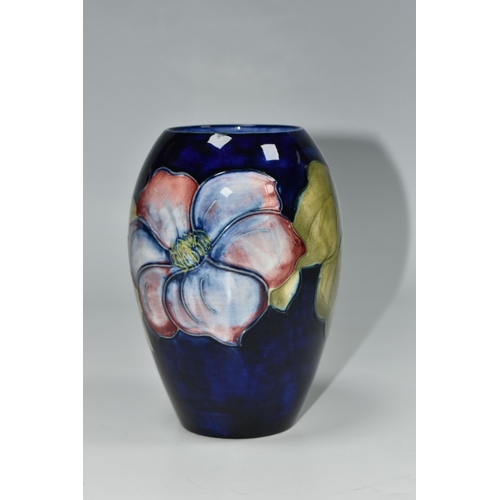 325 - A MOORCROFT POTTERY CLEMATIS PATTERN VASE, the ovoid vase tube lined with purple Clematis flowers on... 