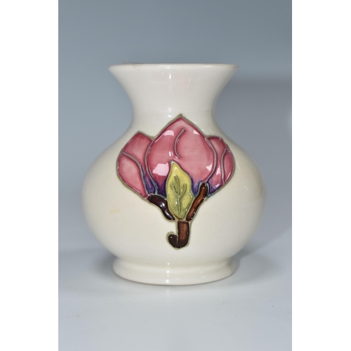 331 - A MOORCROFT POTTERY MAGNOLIA PATTERN VASE, the baluster vase tube lined with pink magnolia flowers o... 