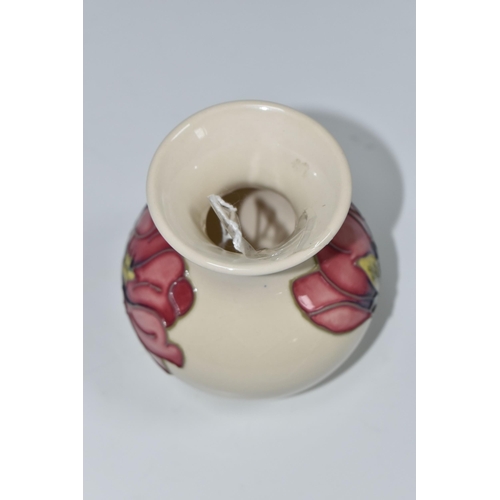 331 - A MOORCROFT POTTERY MAGNOLIA PATTERN VASE, the baluster vase tube lined with pink magnolia flowers o... 