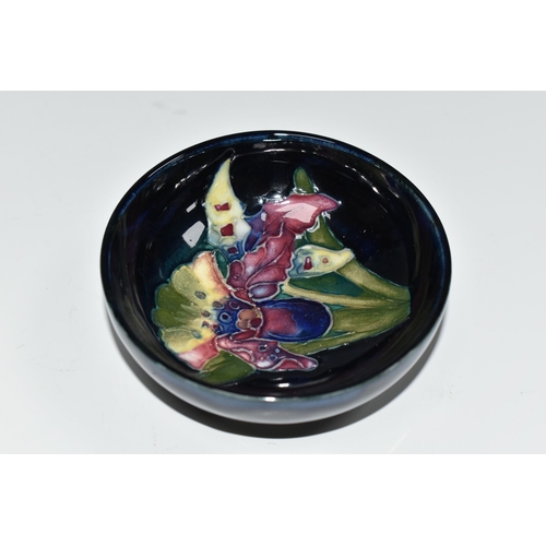 336 - A MOORCROFT POTTERY ORCHID PATTERN BOWL, the footed bowl tube lined with multicoloured orchids on a ... 