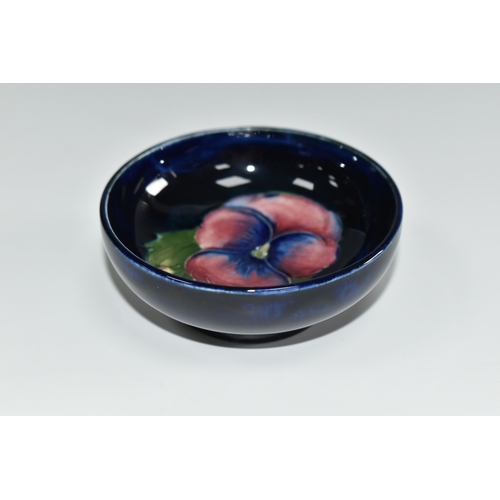 455 - A MOORCROFT POTTERY SMALL FOOTED BOWL, in Pansy pattern on a dark blue ground, diameter 7.5cm x heig... 