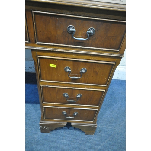 1204 - A 20TH CENTURY YEW WOOD TWIN PEDESTAL DESK, with leather writing surface, fitted with nine assorted ... 