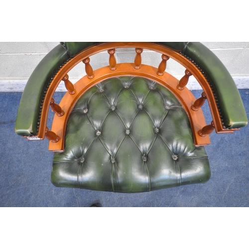 1214 - A REPRODUCTION SWIVEL OFFICE CHAIR, with buttoned green leather upholstery, raised on five shaped le... 