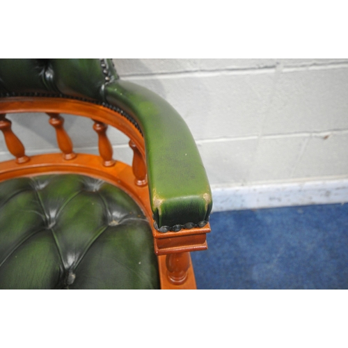 1214 - A REPRODUCTION SWIVEL OFFICE CHAIR, with buttoned green leather upholstery, raised on five shaped le... 