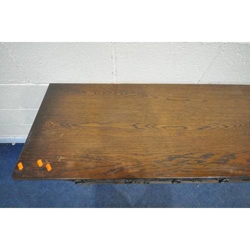 1254 - A 20TH CENTURY OAK SIDEBOARD, fitted with four drawers, above four linenfold cupboard doors, raised ... 