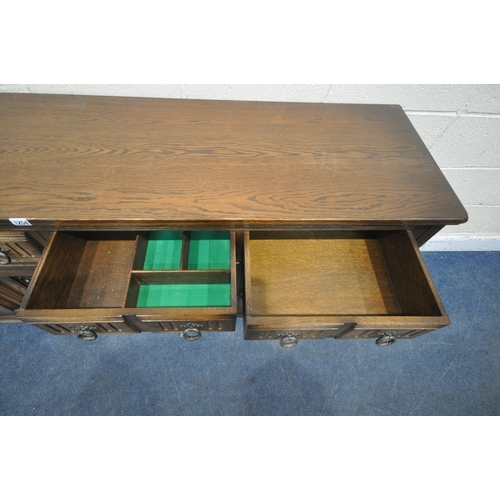 1254 - A 20TH CENTURY OAK SIDEBOARD, fitted with four drawers, above four linenfold cupboard doors, raised ... 