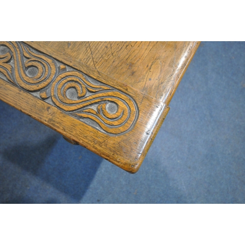 1255 - A 20TH CENTURY OAK TABLE, the two inch rectangular top, raised on bulbous carved supports, shaped le... 