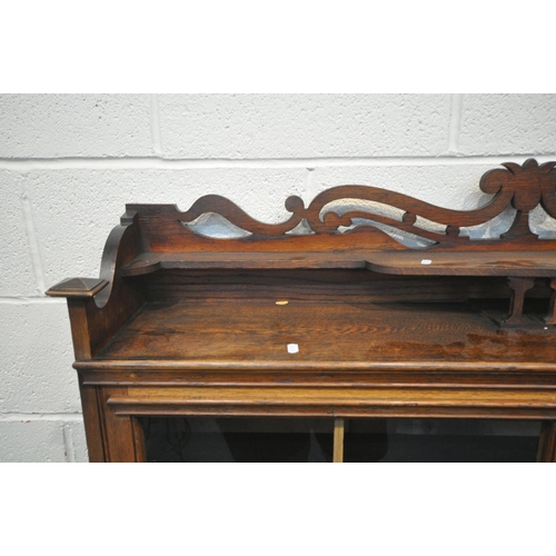 1256 - AN EARLY 20TH CENTURY OAK BOOKCASE, with raised back, double glazed doors, enclosing three shelves, ... 