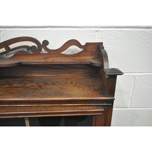 1256 - AN EARLY 20TH CENTURY OAK BOOKCASE, with raised back, double glazed doors, enclosing three shelves, ... 