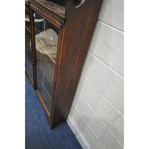 1256 - AN EARLY 20TH CENTURY OAK BOOKCASE, with raised back, double glazed doors, enclosing three shelves, ... 