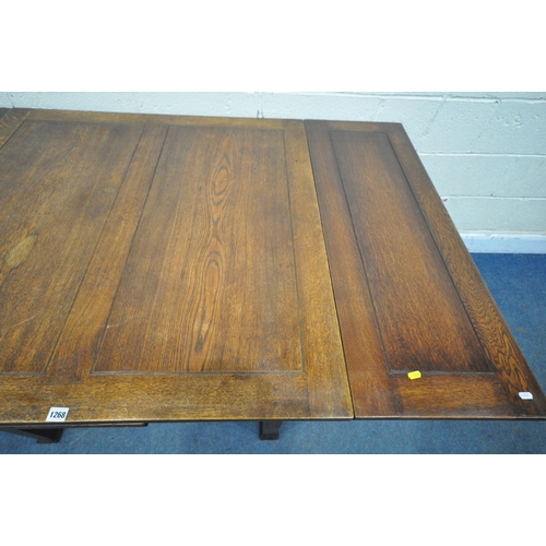 1268 - AN ARTS AND CRAFTS OAK DRAWER LEAF DINING TABLE, raised on square tapered legs, with pad feet, open ... 