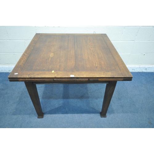 1268 - AN ARTS AND CRAFTS OAK DRAWER LEAF DINING TABLE, raised on square tapered legs, with pad feet, open ... 