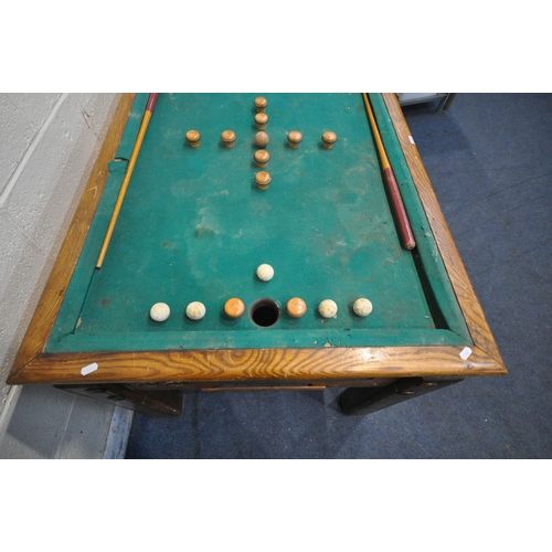 1274 - AN EARLY 20TH CENTURY OAK BUMPER POOL TABLE, with two cues, five red and five white balls, a single ... 