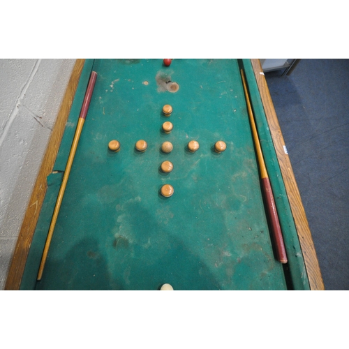 1274 - AN EARLY 20TH CENTURY OAK BUMPER POOL TABLE, with two cues, five red and five white balls, a single ... 