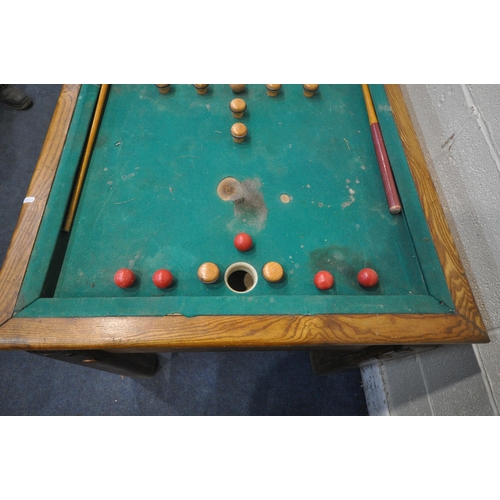 1274 - AN EARLY 20TH CENTURY OAK BUMPER POOL TABLE, with two cues, five red and five white balls, a single ... 