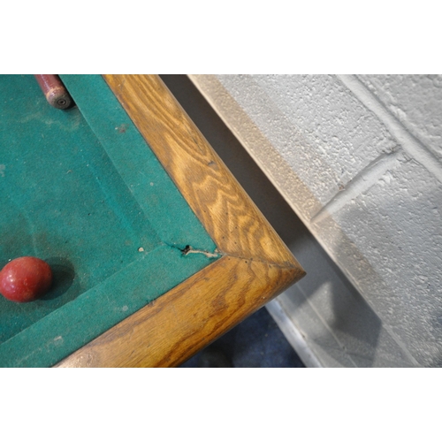 1274 - AN EARLY 20TH CENTURY OAK BUMPER POOL TABLE, with two cues, five red and five white balls, a single ... 