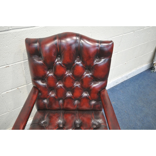 1300 - AN OXBLOOD BUTTONED LEATHER GAINSBOROUGH CHAIR, with arched back rest and open armrests, width 62cm ... 