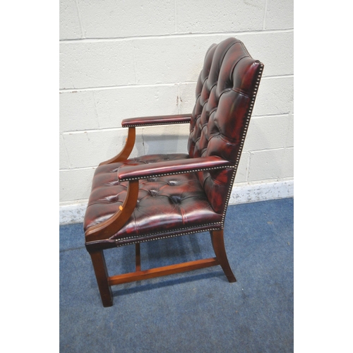 1300 - AN OXBLOOD BUTTONED LEATHER GAINSBOROUGH CHAIR, with arched back rest and open armrests, width 62cm ... 