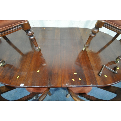 1303 - AN EARLY 20TH CENTURY MAHOGANY OVAL WIND OUT DINING TABLE, raised on cabriole legs, with two additio... 