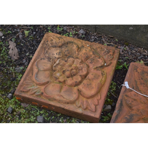 1022 - THREE WEATHERED COMPOSITE TILES, each with a different pattern of a flower head, 30cm squared (condi... 