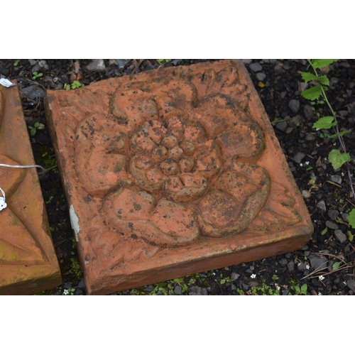 1022 - THREE WEATHERED COMPOSITE TILES, each with a different pattern of a flower head, 30cm squared (condi... 