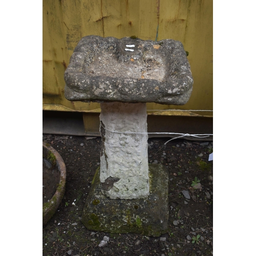 1029 - A WEATHERED COMPOSITE SUNDIAL, on a circular base, diameter 43cm x height 63cm, and a composite bird... 