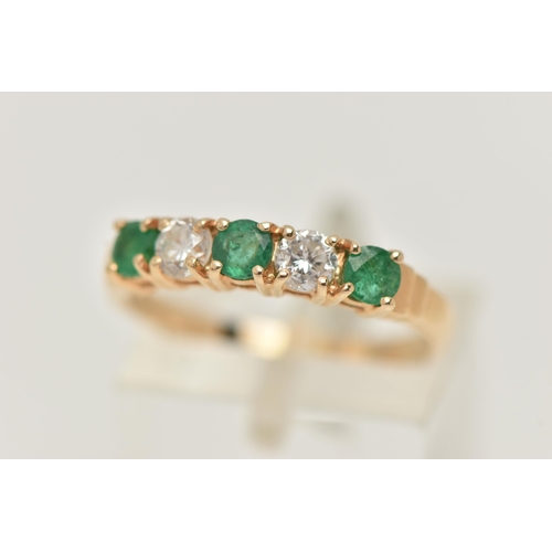 34 - A YELLOW METAL EMERALD AND DIAMOND HALF ETERNTIY RING, set with two round brilliant cut diamonds, ea... 