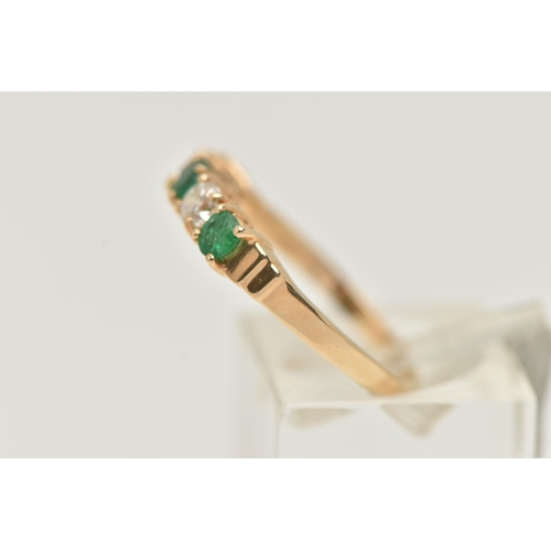 34 - A YELLOW METAL EMERALD AND DIAMOND HALF ETERNTIY RING, set with two round brilliant cut diamonds, ea... 