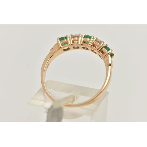 34 - A YELLOW METAL EMERALD AND DIAMOND HALF ETERNTIY RING, set with two round brilliant cut diamonds, ea... 