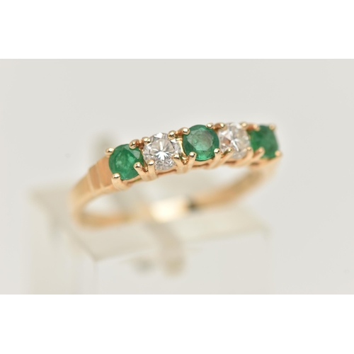 34 - A YELLOW METAL EMERALD AND DIAMOND HALF ETERNTIY RING, set with two round brilliant cut diamonds, ea... 