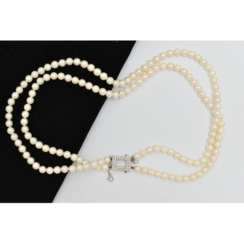 51 - A DOUBLE STRAND OF CULTURED PEARLS WITH DIAMOND CLASP, round white cultured pearls with pink underto... 