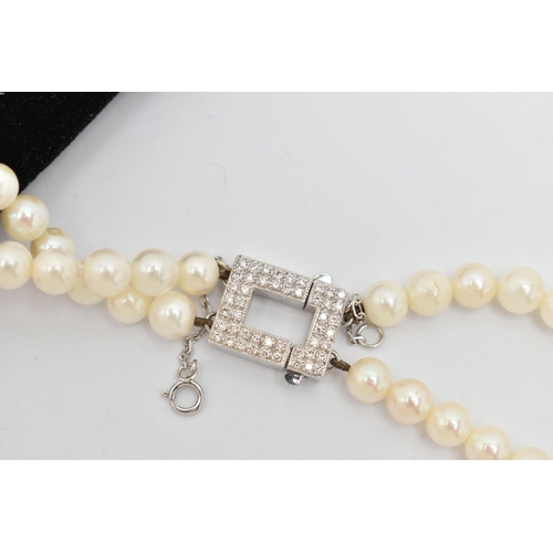 51 - A DOUBLE STRAND OF CULTURED PEARLS WITH DIAMOND CLASP, round white cultured pearls with pink underto... 