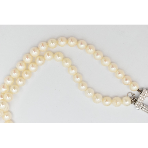 51 - A DOUBLE STRAND OF CULTURED PEARLS WITH DIAMOND CLASP, round white cultured pearls with pink underto... 