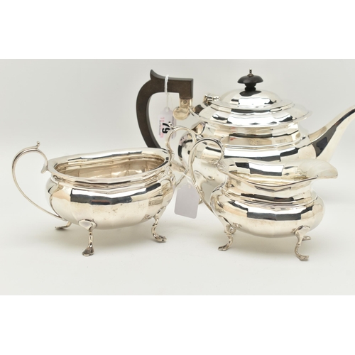 79 - A GEORGE V SILVER THREE PIECE TEA SET, of a faceted design, comprising of a teapot fitted with an eb... 