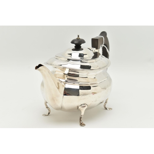 79 - A GEORGE V SILVER THREE PIECE TEA SET, of a faceted design, comprising of a teapot fitted with an eb... 