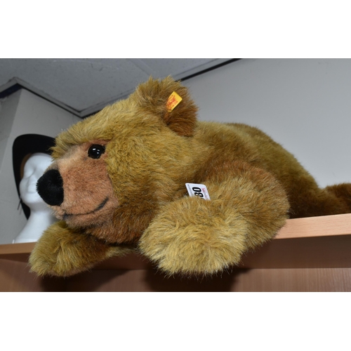 380 - A STEIFF URS BROWN BEAR, No.069673, soft plush brown bear in a lying position, button and tag to lef... 