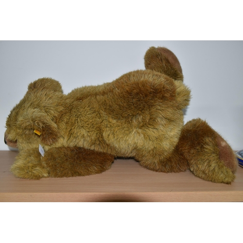 380 - A STEIFF URS BROWN BEAR, No.069673, soft plush brown bear in a lying position, button and tag to lef... 