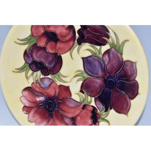 416 - A MOORCROFT POTTERY 'ANEMONE' PATTERN PLATE, tube lined with pink and purple anemones on a pale yell... 