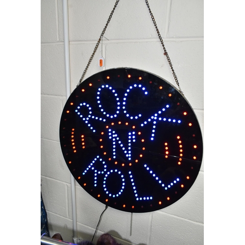 531 - A CIRCULAR BLACK WALL HANGING ILLUMINATING LED SIGN 'ROCK N ROLL', hanging on a metal chain, diamete... 