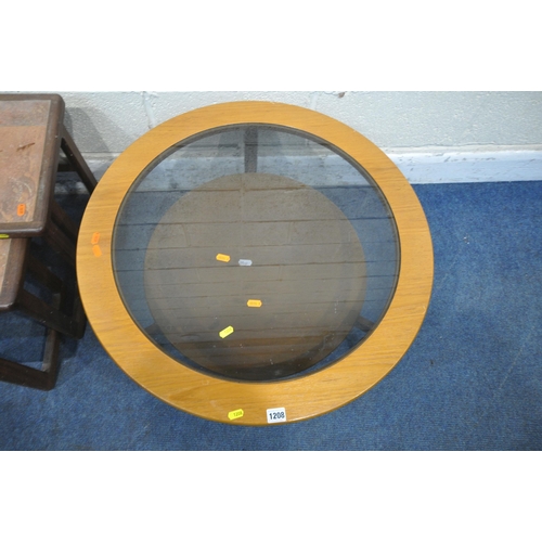 1208 - A MID CENTURY TEAK CIRCULAR COFFEE TABLE, with a smoked glass insert, raised on three legs, united b... 