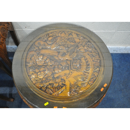 1215 - AN ORIENTAL CIRCULAR COFFEE TABLE, with intricate carved details of birds and trees, raised on four ... 