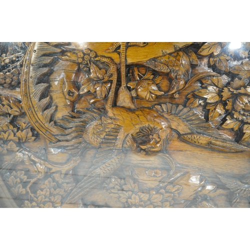 1215 - AN ORIENTAL CIRCULAR COFFEE TABLE, with intricate carved details of birds and trees, raised on four ... 