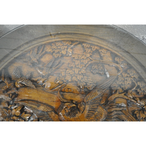 1215 - AN ORIENTAL CIRCULAR COFFEE TABLE, with intricate carved details of birds and trees, raised on four ... 