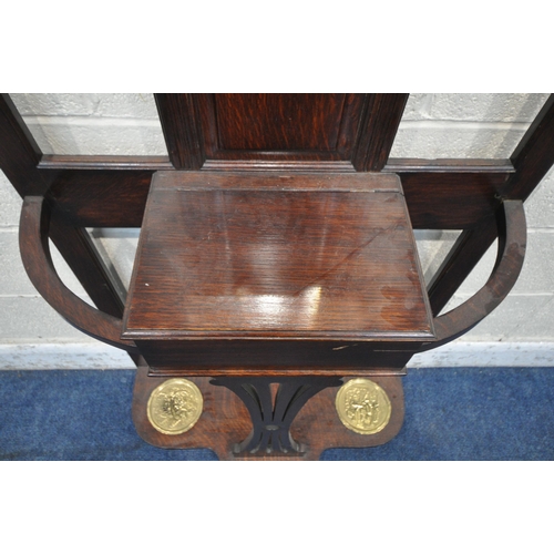 1219 - AN EARLY 20TH CENTURY OAK HALL STAND, with a central rectangular bevelled edge mirror, a hinged stor... 