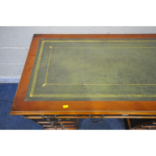 1234 - A REPRODUCTION YEWWOOD TWIN PEDESTAL DESK, with a green leather writing surface, fitted with nine dr... 