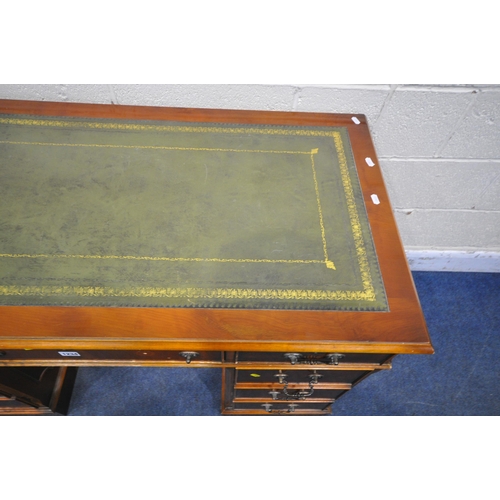 1234 - A REPRODUCTION YEWWOOD TWIN PEDESTAL DESK, with a green leather writing surface, fitted with nine dr... 