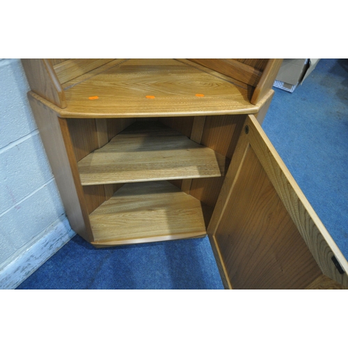 1258 - LUCIAN ERCOLANI, A MID CENTURY ELM AND BEECH WINDSOR CORNER CUPBOARD, fitted with two shelves, above... 