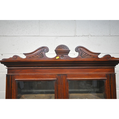 1262 - AN EDWARDIAN MAHOGANY BOOKCASE, with a scrolled crest, the double glazed doors, enclosing three shel... 